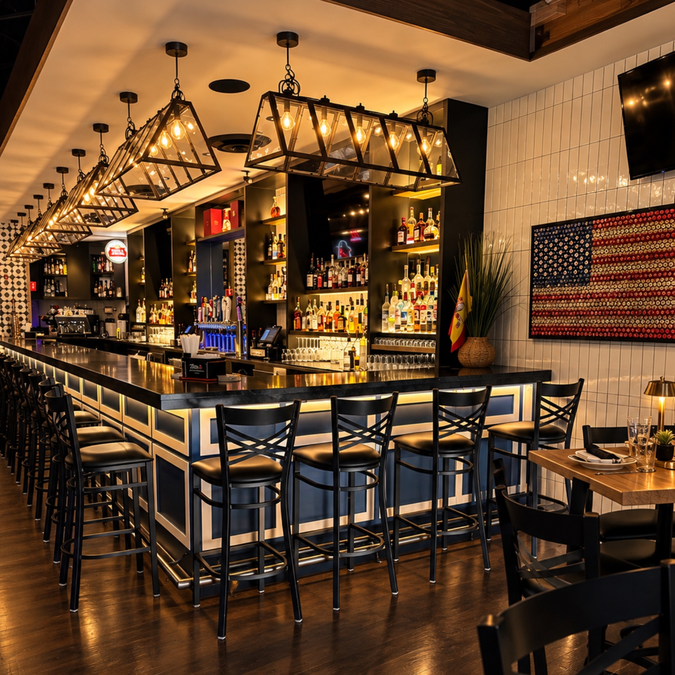 Upscale restaurant bar with liquor shelves, glowing pendant lights, navy-and-white counters, and rows of black bar stools.