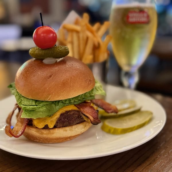 A Bar 141 bacon cheeseburger with lettuce, pickles, fries, and a beer.