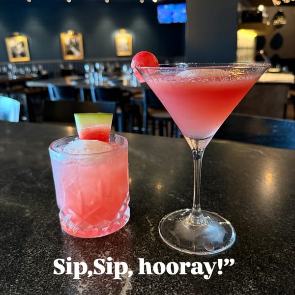 Two pink watermelon cocktails, one in a martini glass and one in a rocks glass, on a bar.